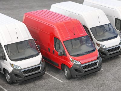Red delivery van in a row of white vans. Best express delivery and shipmentt service concept.